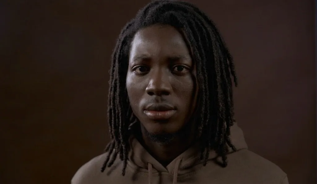 Locs hasta los hombros, raya al lado, sueltos.